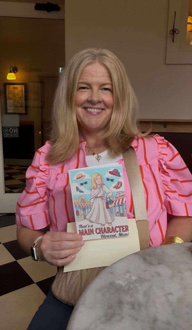 A mom holding a card that illustrates her as the main character